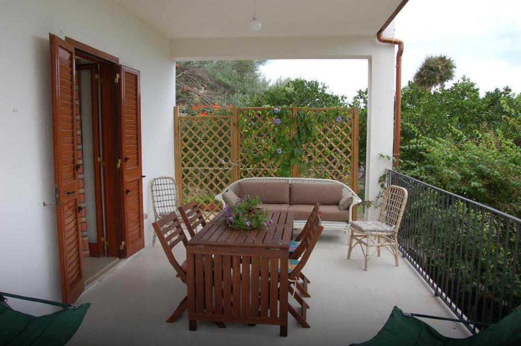 un patio con sofá, mesa y sillas en Casa del Gelso Mortelle, en Torre Faro
