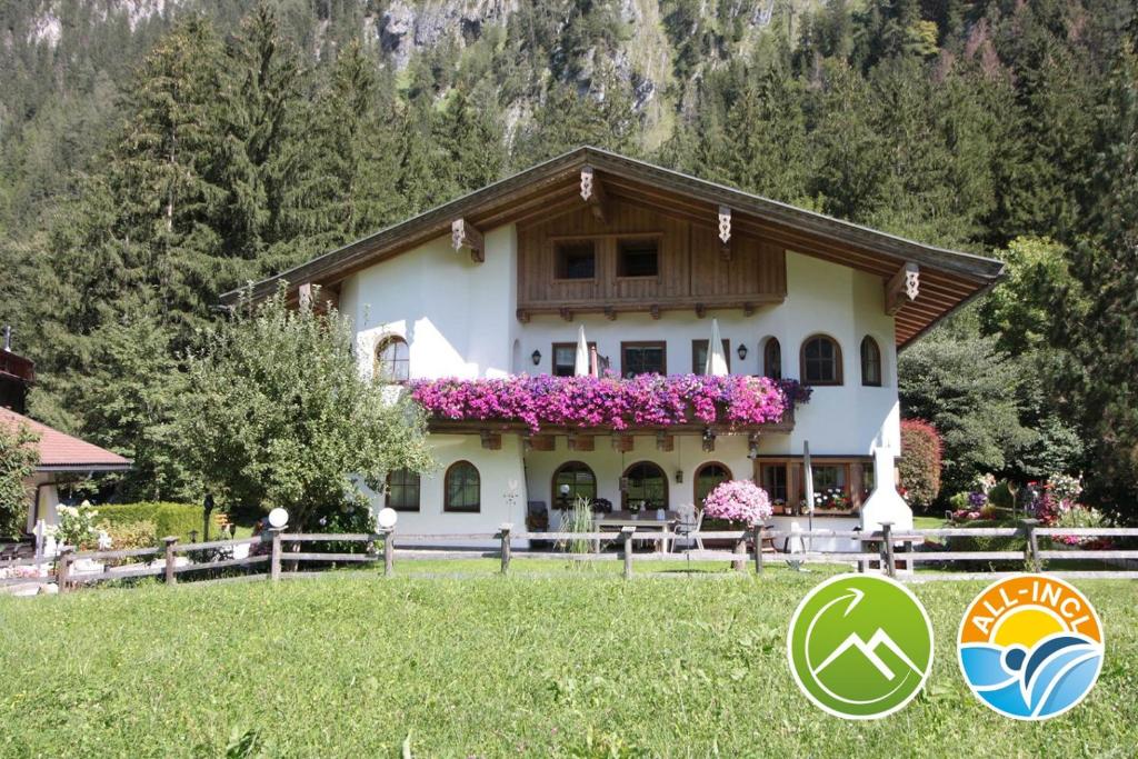 a house with flowers on the front of it at Vronis Waldhaus ADULTS ONLY in Mayrhofen