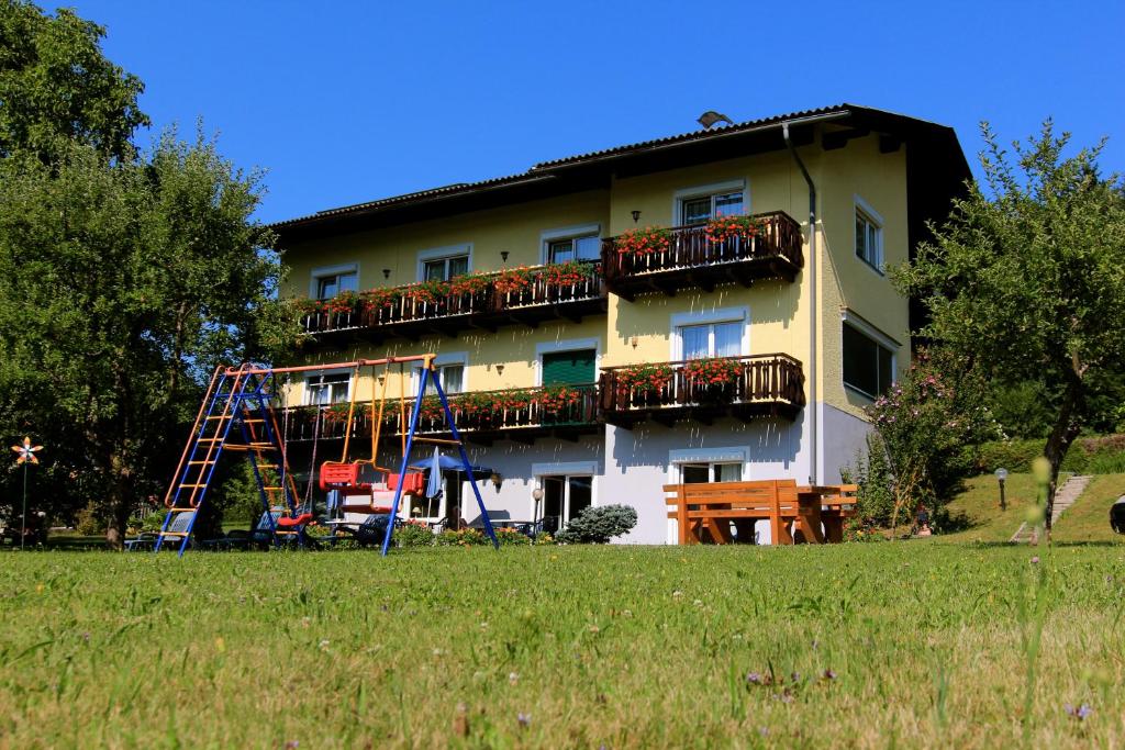 ein Gebäude mit einem Spielplatz davor in der Unterkunft Pension Sonnengrund in Reifnitz