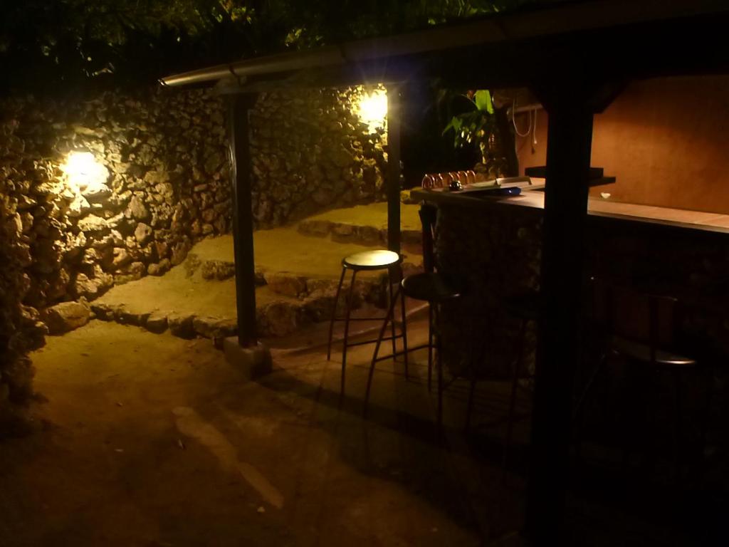 a bar at night with a table and chairs at Taketomijima Akaneya in Taketomi
