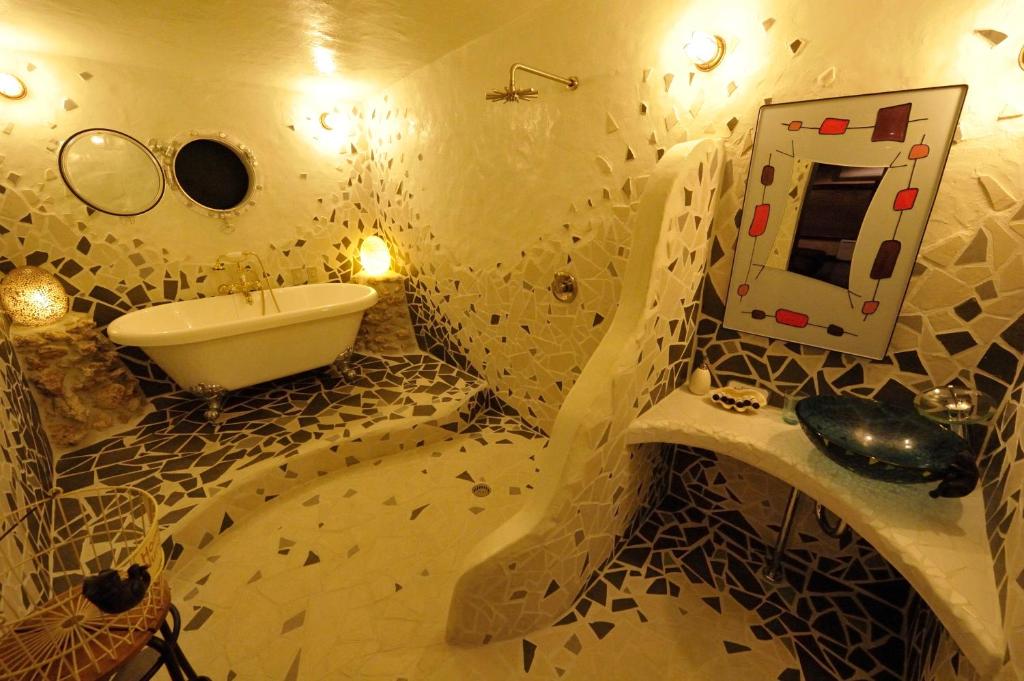 a bathroom with a sink and a tub and a mirror at Taketomijima Akaneya in Taketomi