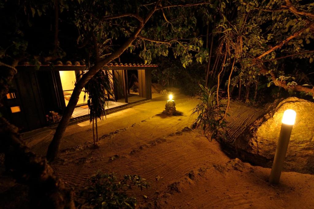 a lit up fire hydrant at night with two candles at Taketomijima Akaneya in Taketomi