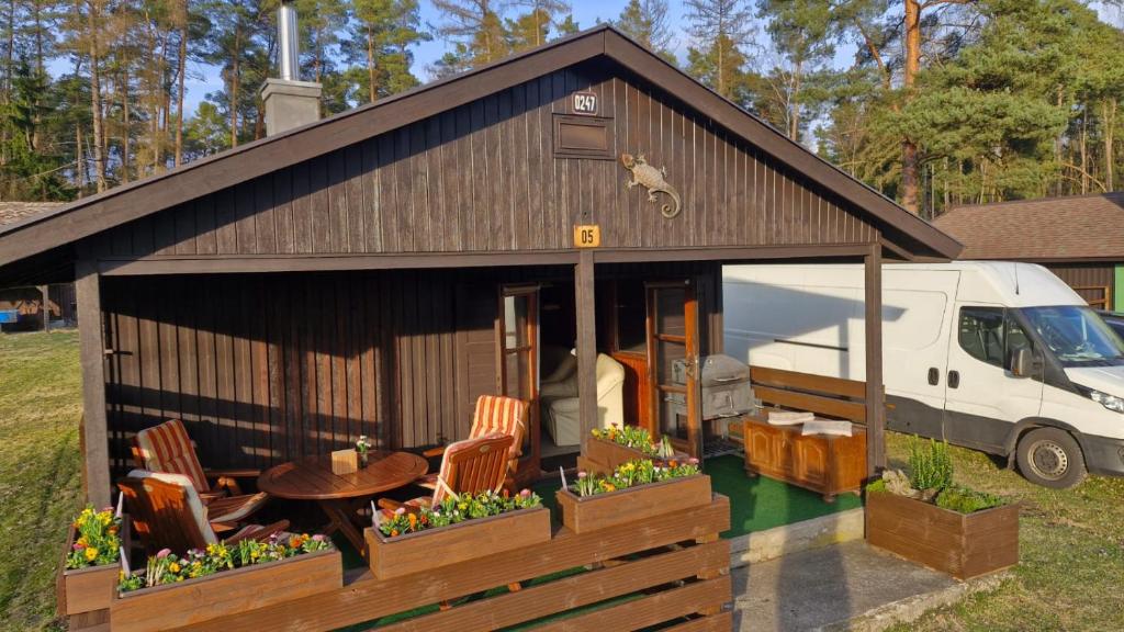 a building with chairs and a table and a van at Chata Ještěrka in Doksy