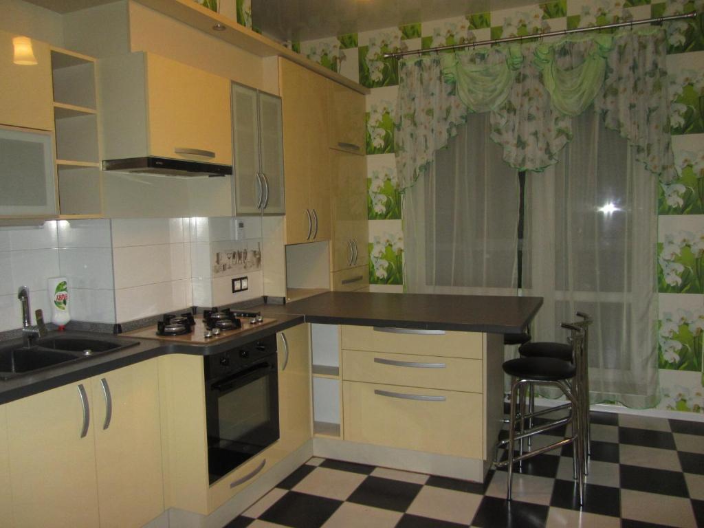 カリーニングラードにあるApartment on Dmitriya Donskogo 20のキッチン(白いキャビネット、シンク、コンロ付)