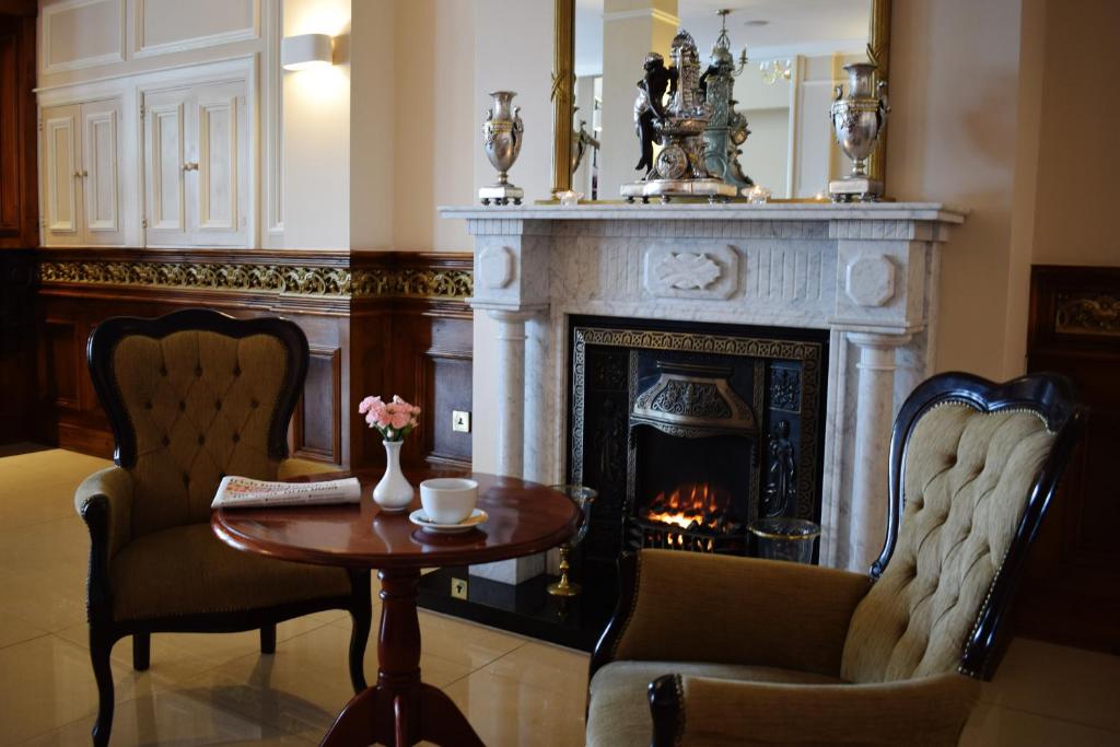 a living room with a fireplace and a table and chairs at Bay View Hotel in Killybegs