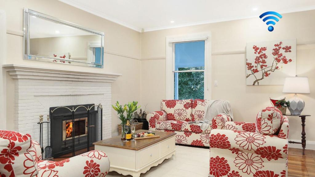 a living room with two chairs and a fireplace at The Foldgarth in Burradoo