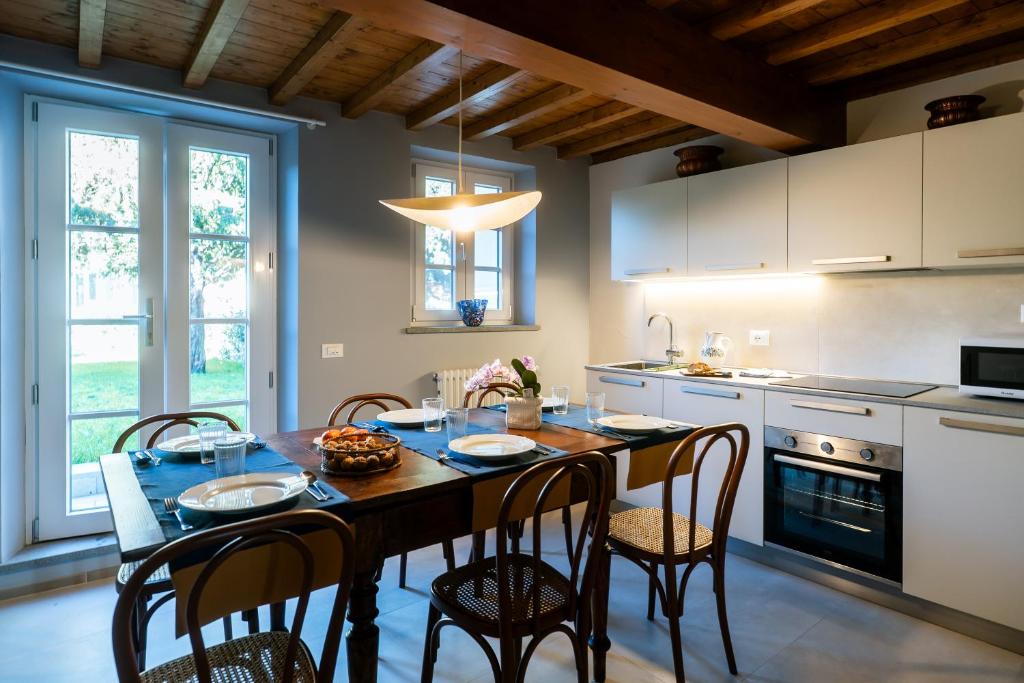 a kitchen with a table and chairs and a kitchen with white cabinets at Lo scrigno di Camilla in Capannori