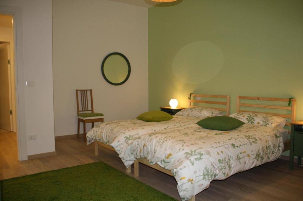 ボローニャにあるLa casa di Kroのベッドルーム1室(緑の枕と鏡付きのベッド1台付)