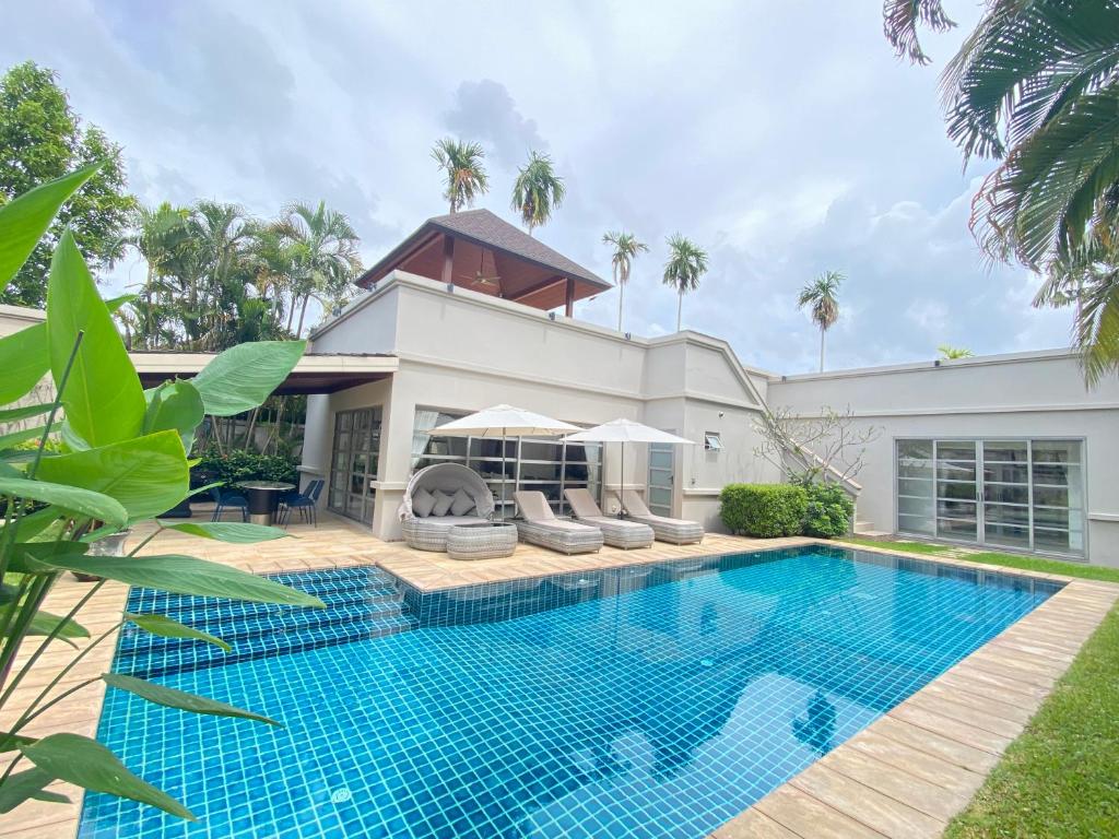 a swimming pool in front of a house at Residence Villa 3 Bedroom in Bang Tao Beach