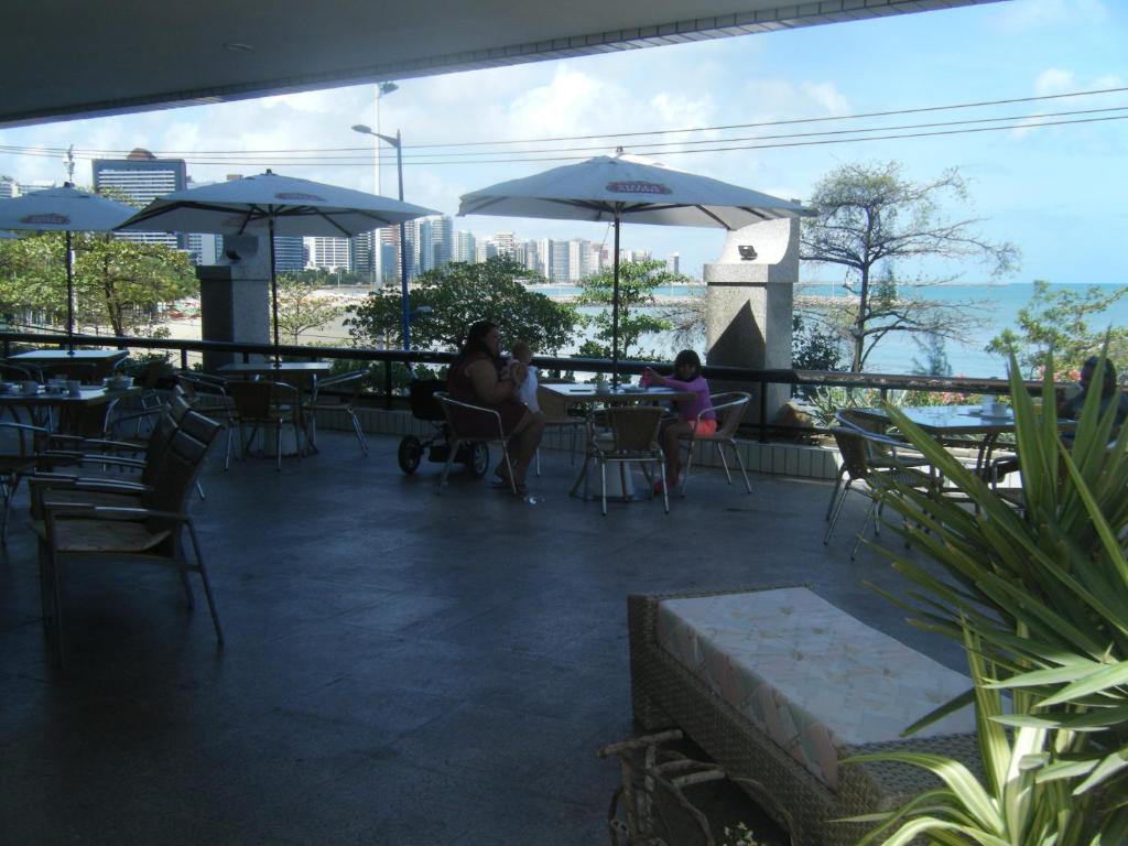 twee personen op een patio met tafels en parasols bij Fortaleza 703--Fortaleza 713 in Fortaleza