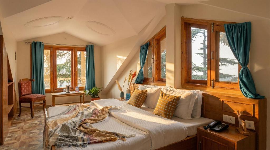 a bedroom with a bed in a room with windows at Kalra Regency Shimla in Shimla