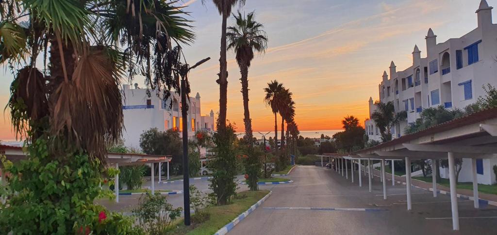 an empty street with palm trees and a building at Élégant appartement de 3 chambres vue piscine n4 in M'diq