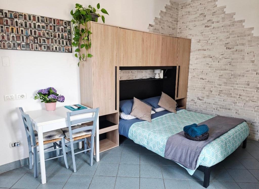 a bedroom with a bed and a table and a desk at Vinessa Home in Peschiera del Garda