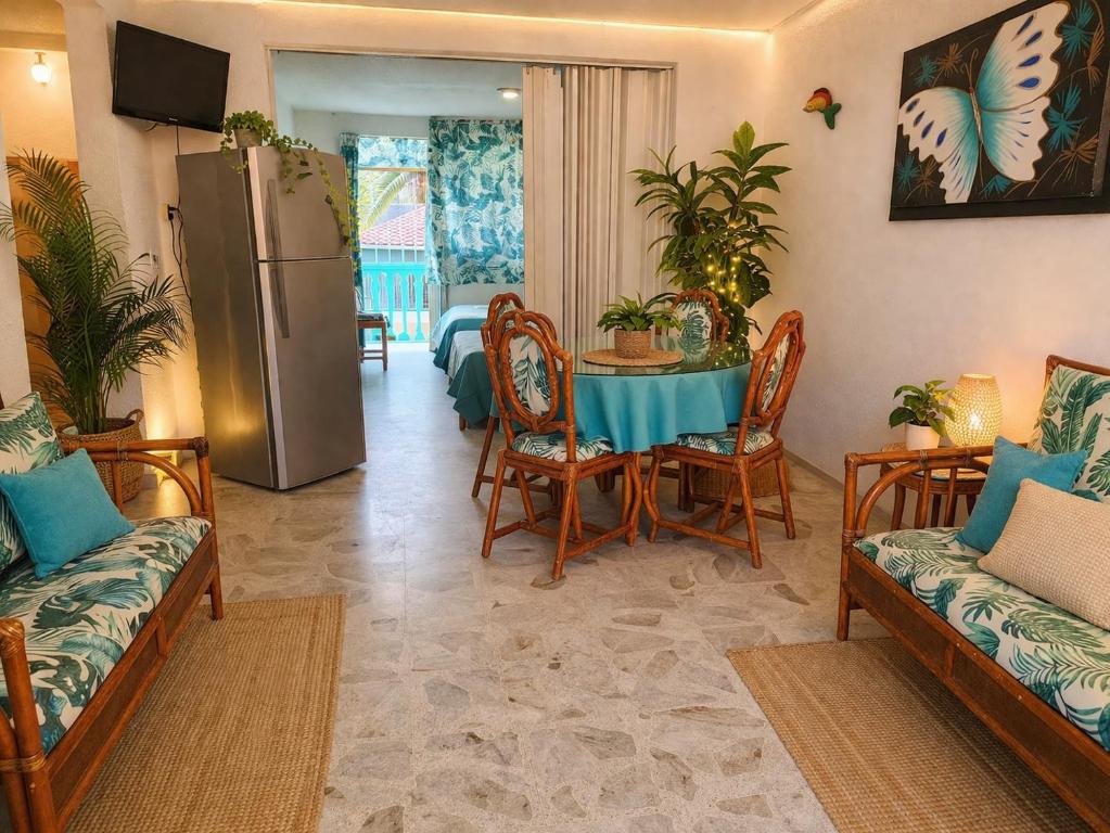 a living room with a table and a refrigerator at Suites Acapulco Real in Acapulco