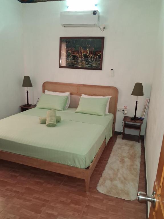a bedroom with a large bed with green sheets at studio maryphil in Saint-Martin