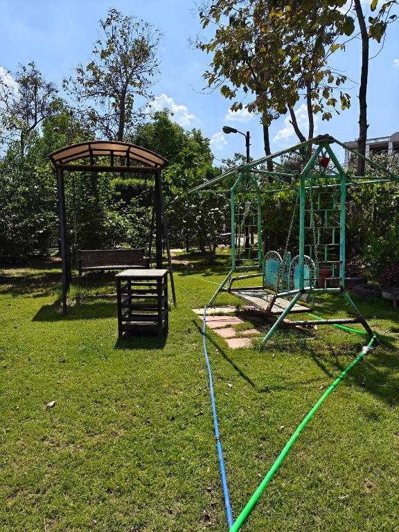 a park with a swing set and a playground at Chandrakanta farm stay in Lucknow