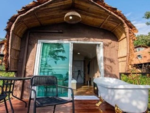 a building with an archway with a tub and chairs at Olympus khaoyai in Ban Nong Makha