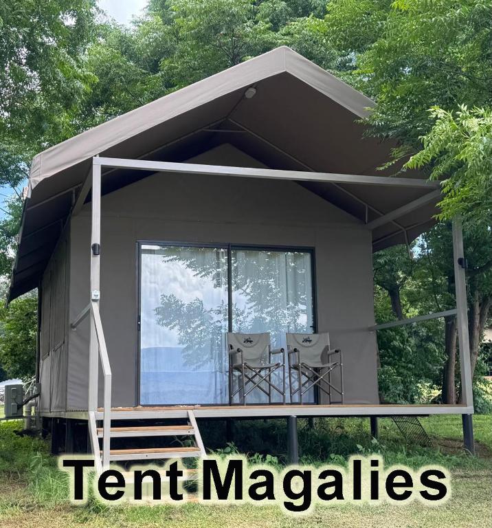 a tiny house with a porch and two chairs at Jacil Riverside Accommodation in Hekpoort