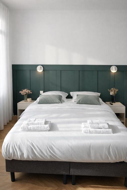 a large white bed with two towels on it at Le Thuillat Limoges in Limoges