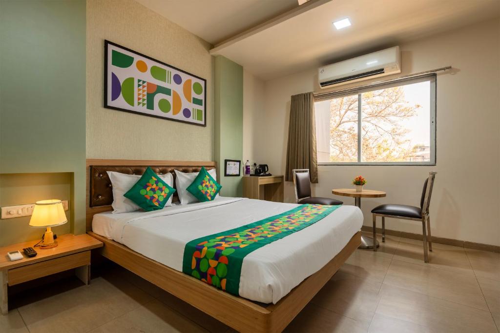 a hotel room with a bed and a window at Treebo Royal Empire in Chinchwad