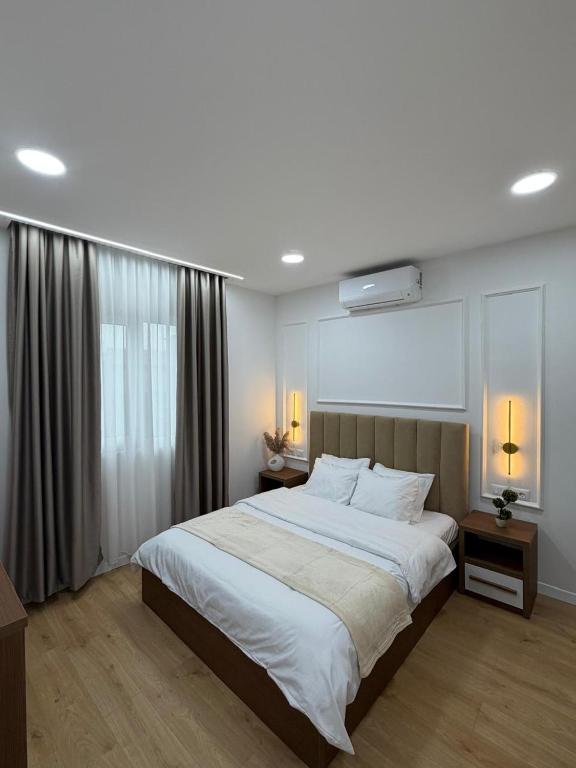 a bedroom with a large white bed and a window at Loris Rooms in Yrshek