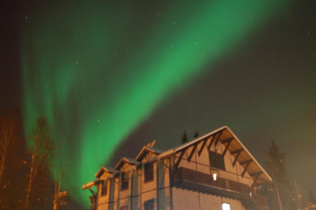 Ein Haus mit der Aurora im Himmel in der Unterkunft Abbey Archway Inn in Fairbanks