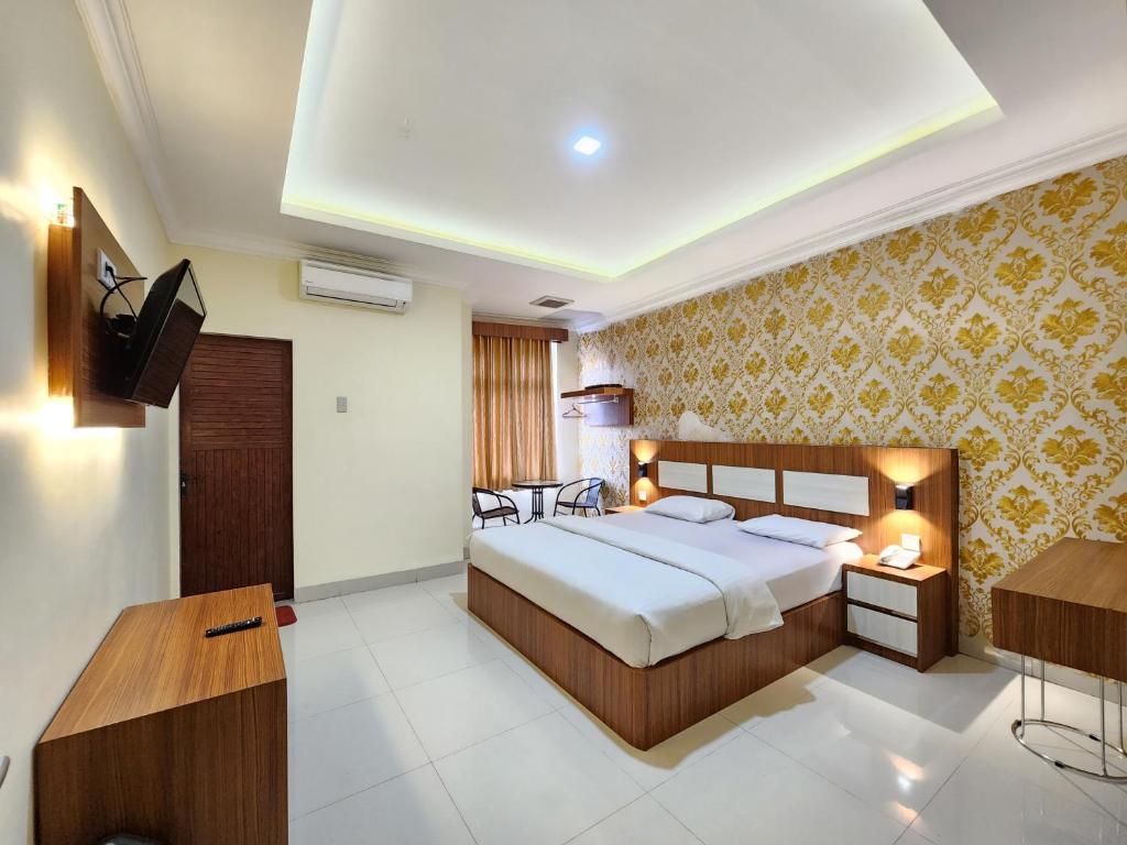 a hotel room with a bed and a television at hotel diana in Banda Aceh