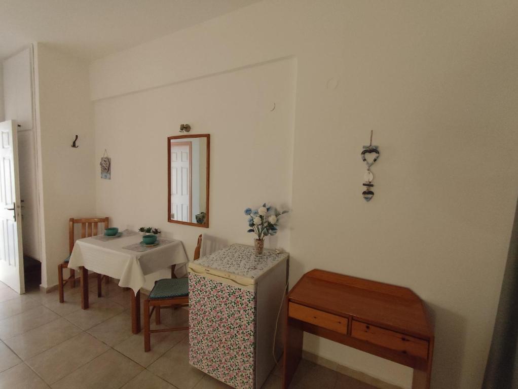 a room with a table and a table and a mirror at Vangelis rooms in Pitsidia