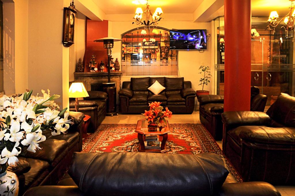 sala de estar con sofás de cuero y mesa en Casona Plaza Hotel Puno, en Puno