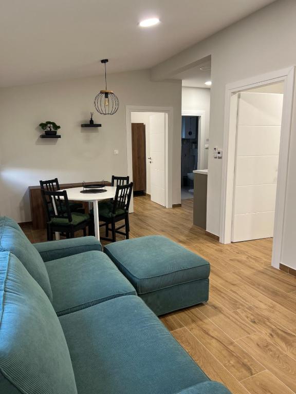 a living room with a blue couch and a table at Apartman Lea in Sibinj