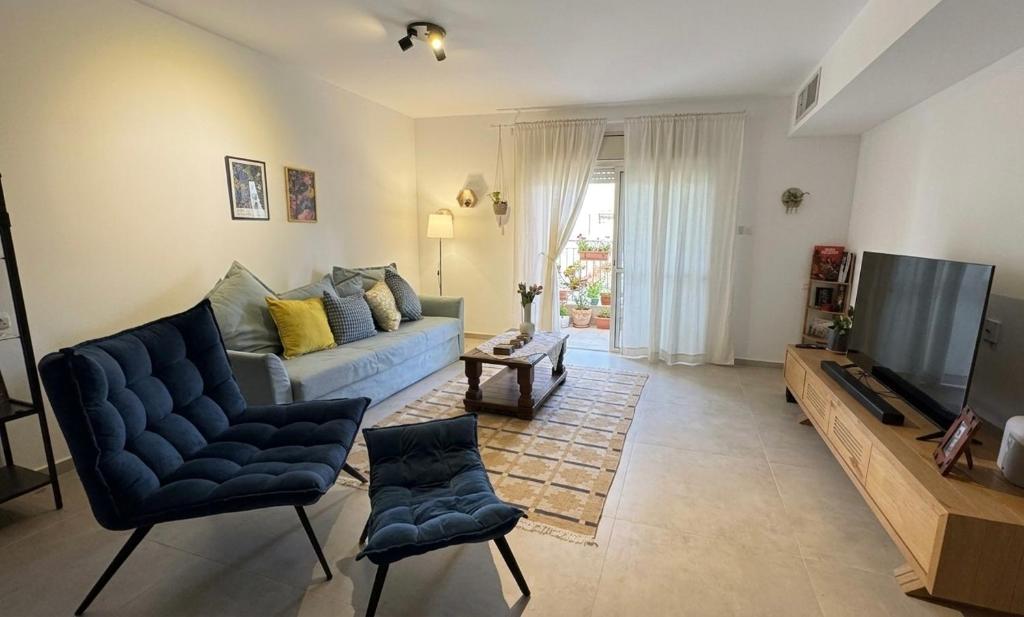 a living room with a blue couch and a television at בית נעים בין המדבר לים in Eilat
