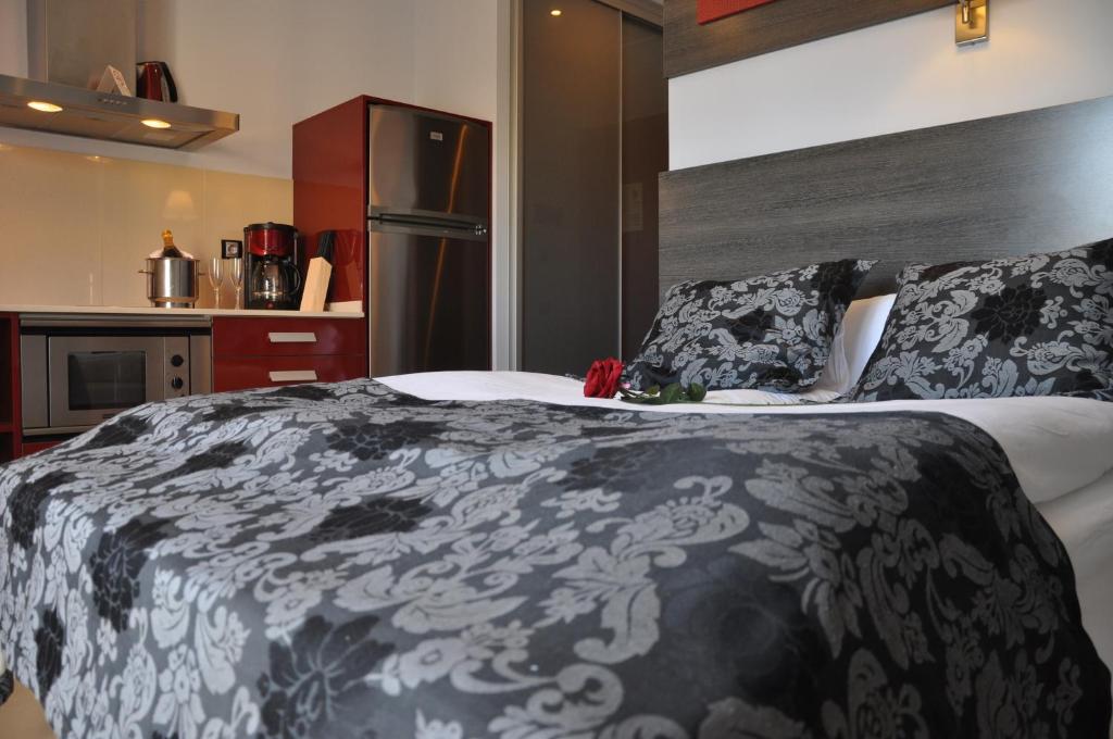 a bedroom with a bed with a black and white blanket at Casablanca Suites - Adults Only in Calella