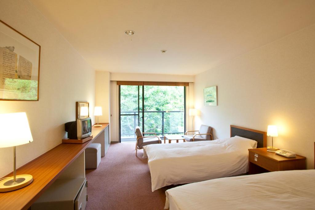Postel nebo postele na pokoji v ubytování Shiki Resort Gora Saika