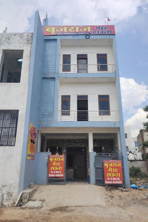 a blue and white building with orange signs on it at बृजराज गेस्ट हाउस & rooms in Rīngas