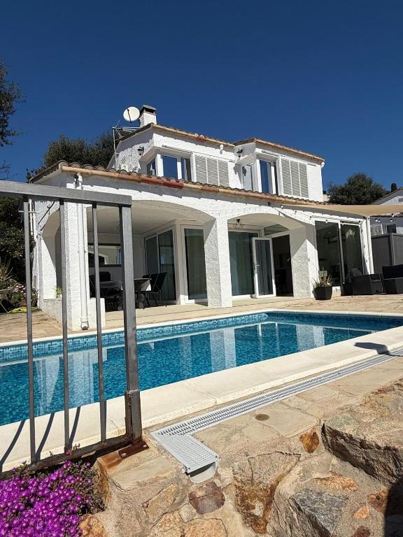 a house with a swimming pool in front of it at Villa Bouganvilla Parking privado 32 en la playa in Tossa de Mar