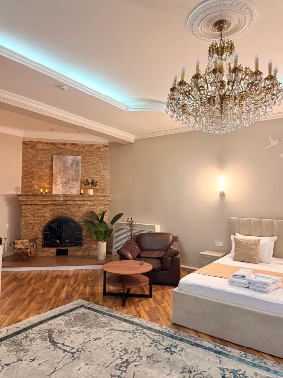 a living room with a bed and a chandelier at Prima Villa Boutique Hotel отель in Semey