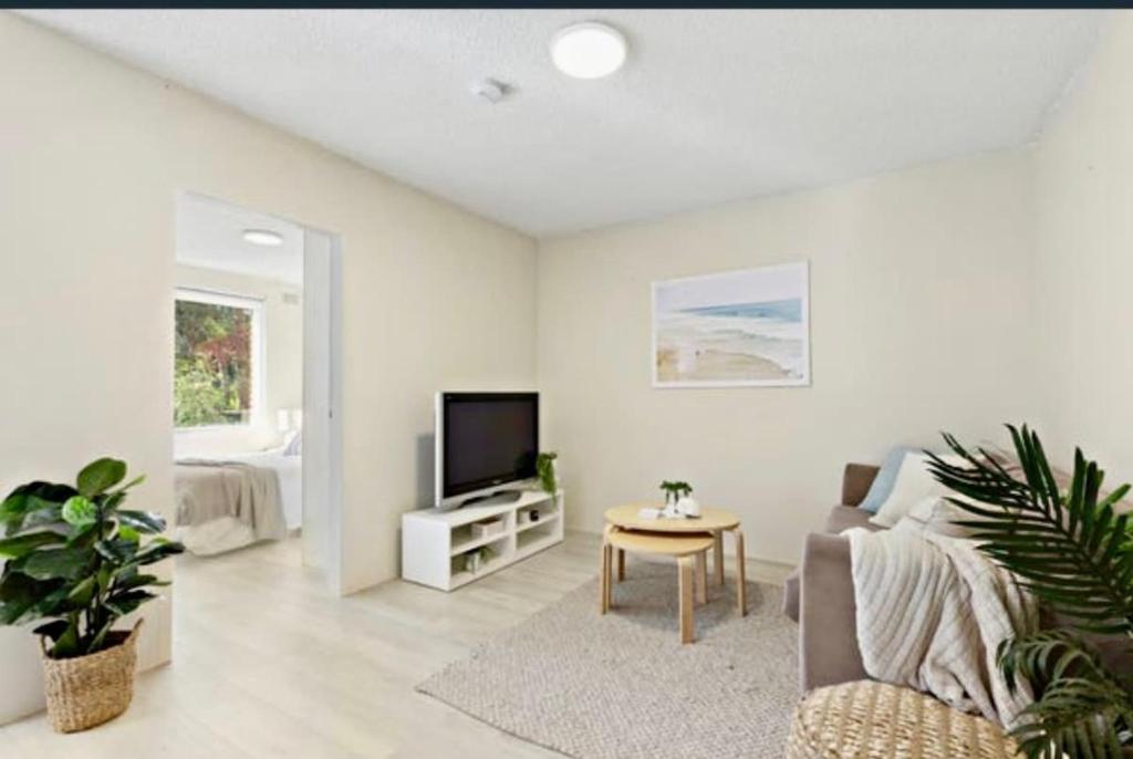 a living room with a couch and a television at Footsteps to Freshwater Beach in Freshwater