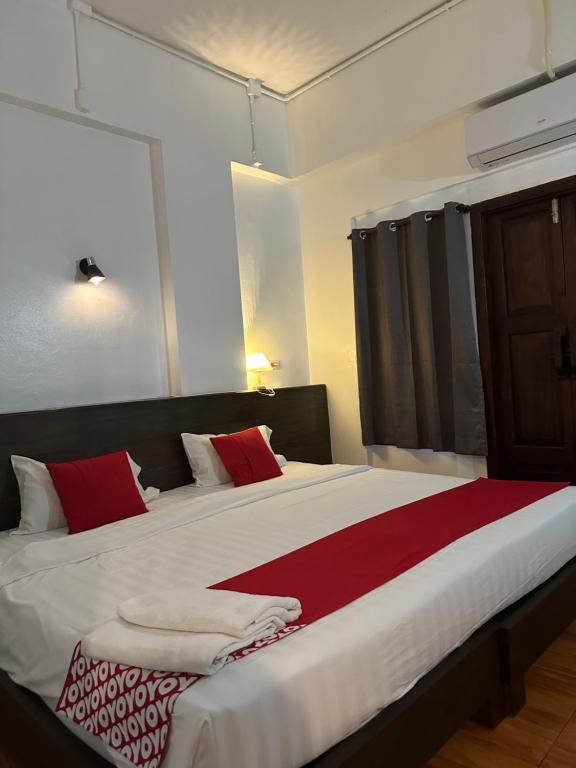 a bedroom with a large bed with red and white pillows at Sk Phuket Old Town in Phuket