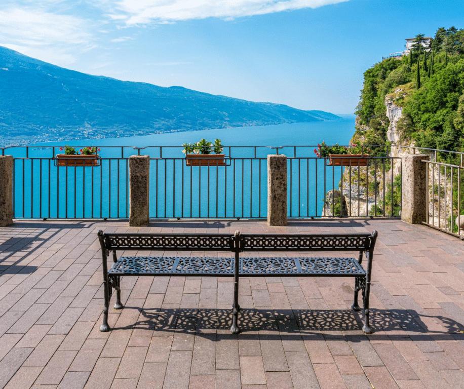 a bench sitting on a patio overlooking the water at La Rotonda apartments by Gardadomusmea in Tremosine Sul Garda