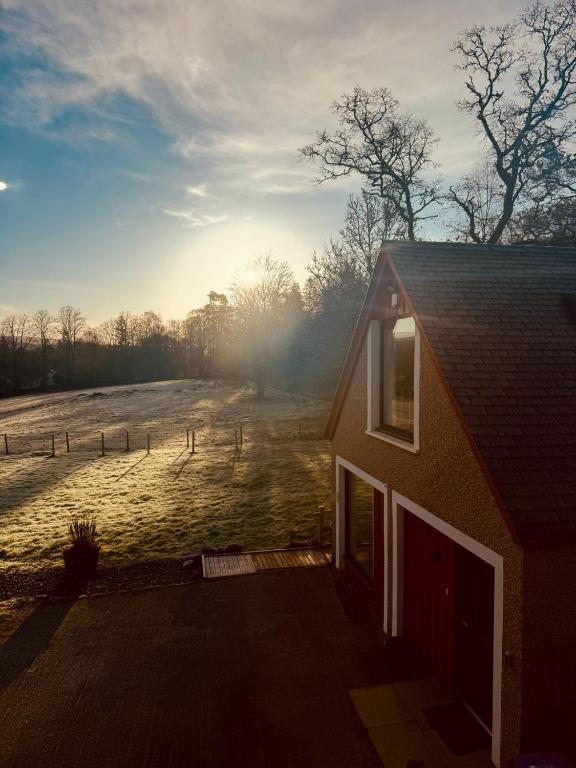 a house with a snowy field in the background at Westmains Lodge in Callander