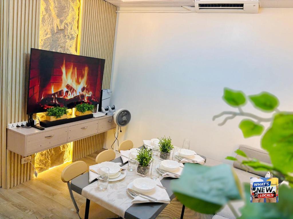 a living room with a table and a fireplace at URBAN CHIC 1Bedroom Condo Unit at MesaVirre with PlayStation 5, Pool view, and Sunset view in Bacolod