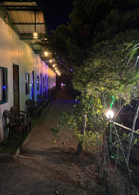 a row of tables and chairs next to a building at night at Maasa Retreat & Resort in Shivpuri