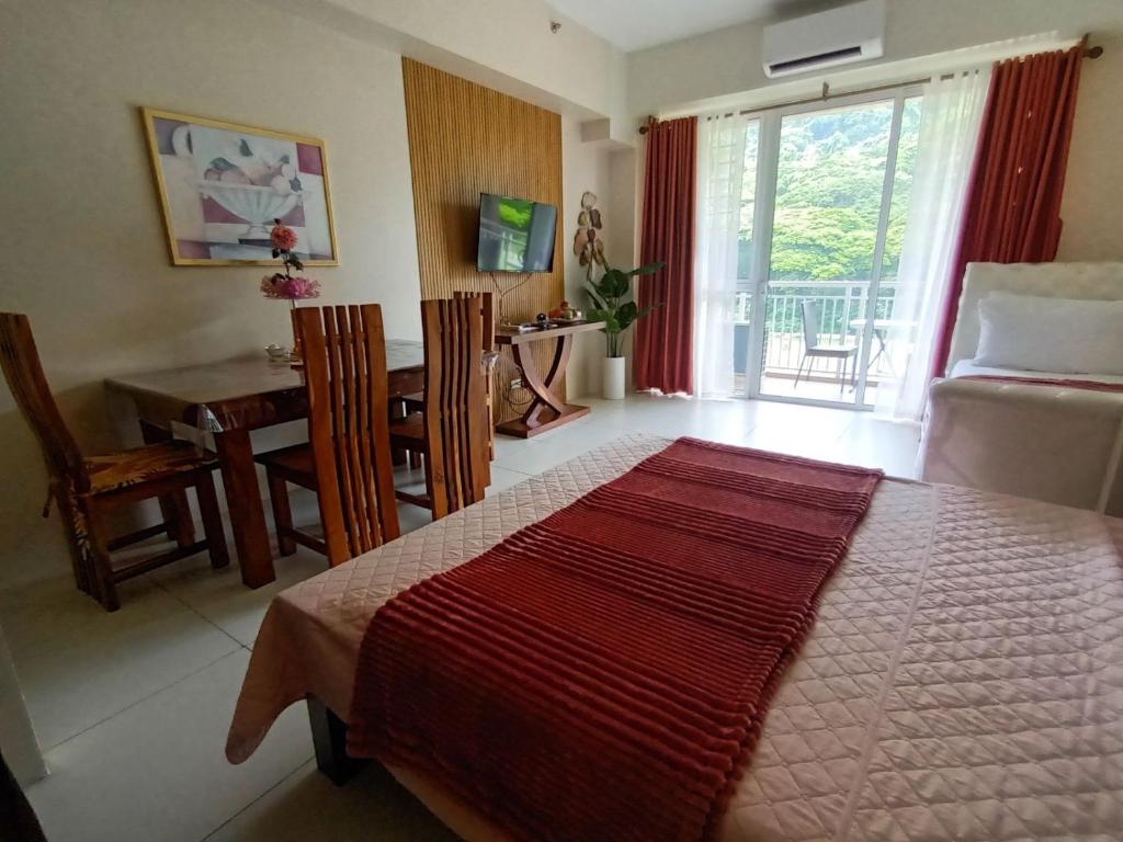 a bedroom with a bed and a dining room with a table at Shirley Pico de Loro 1BR in Nasugbu