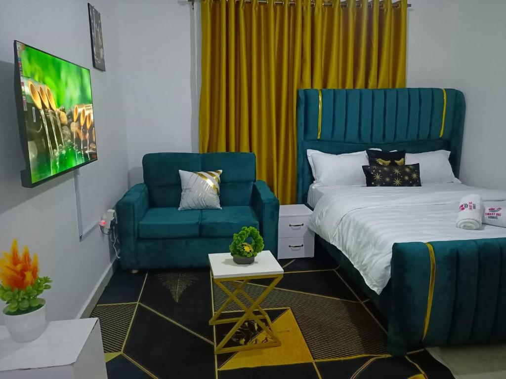 a bedroom with a bed and a couch and a chair at Bnb syokimau in Syokimau