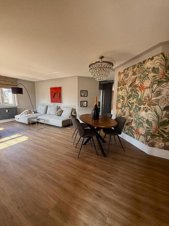 a living room with a table and a couch at CASAMA am See in Langenargen