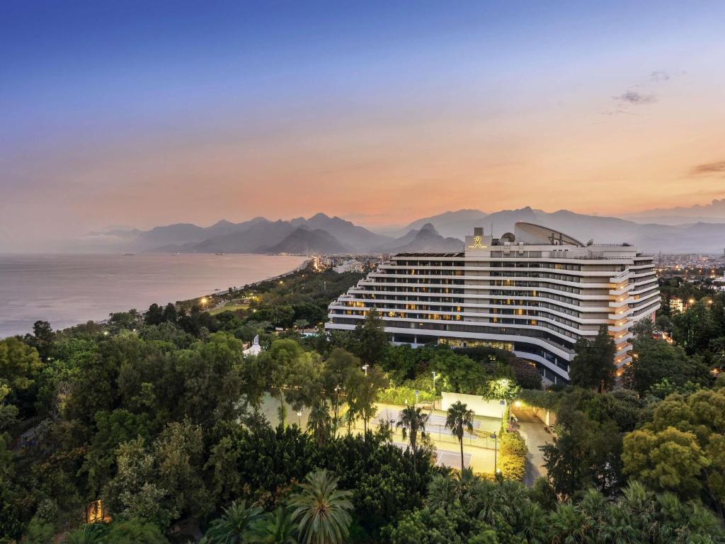 ein Hotel mit Blick auf das Meer und die Berge in der Unterkunft Rixos Downtown Antalya - The Land Of Legends Access in Antalya