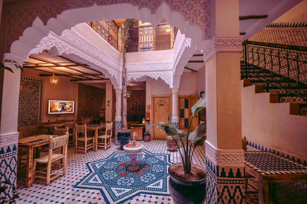 a room with a staircase and a table and chairs at Riad Bleu Azahraa in Safi