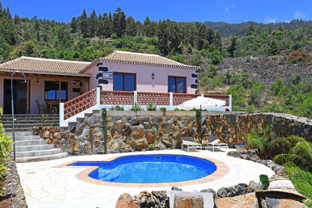 a villa with a swimming pool and a house at Casa La Castellana in Tijarafe