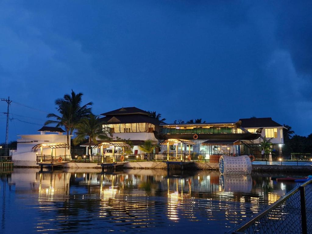 a large building with lights on the water at night at S Cross Munroe Island Resort in Munroe Island