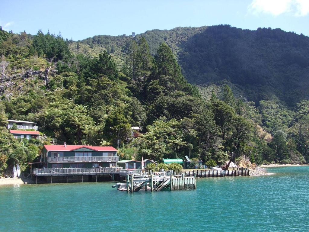 a house on a dock in the middle of a lake at The Lodge At Te Rawa in Te Rawa